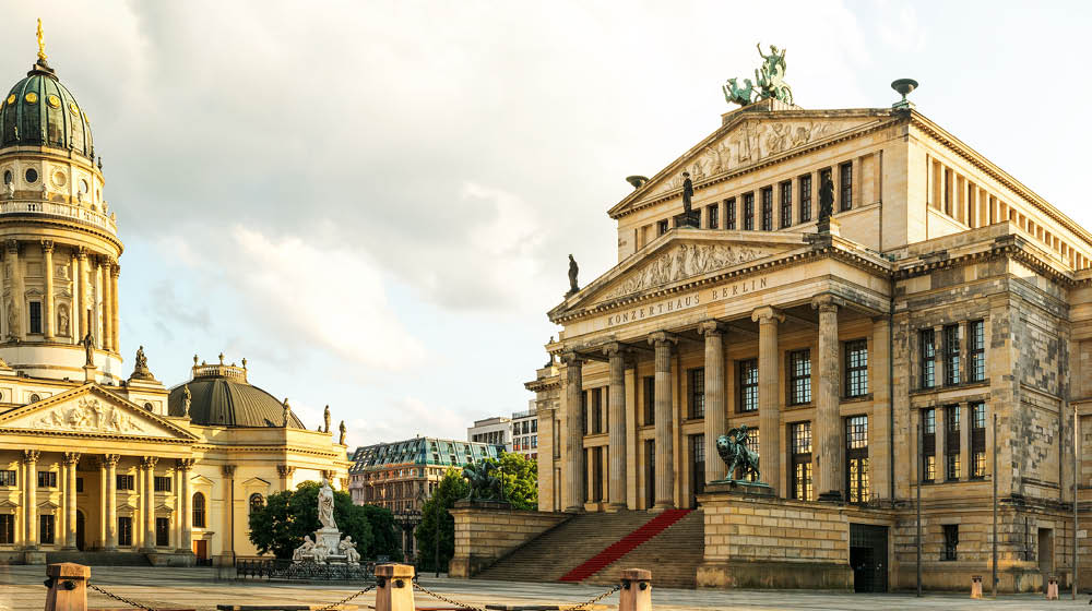 Panoramic Gendarmenmarkt square with German Cathedral in golden evening light at sunset with clouds, Berlin Mitte district