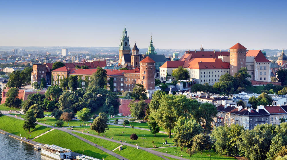 Historic royal Wawel castle in Cracow, Poland with park and Vistula river. Aerial view at sunset.