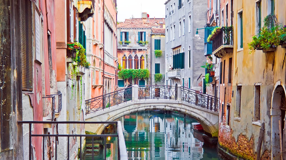A canal and old white bridge in Venice, Italy