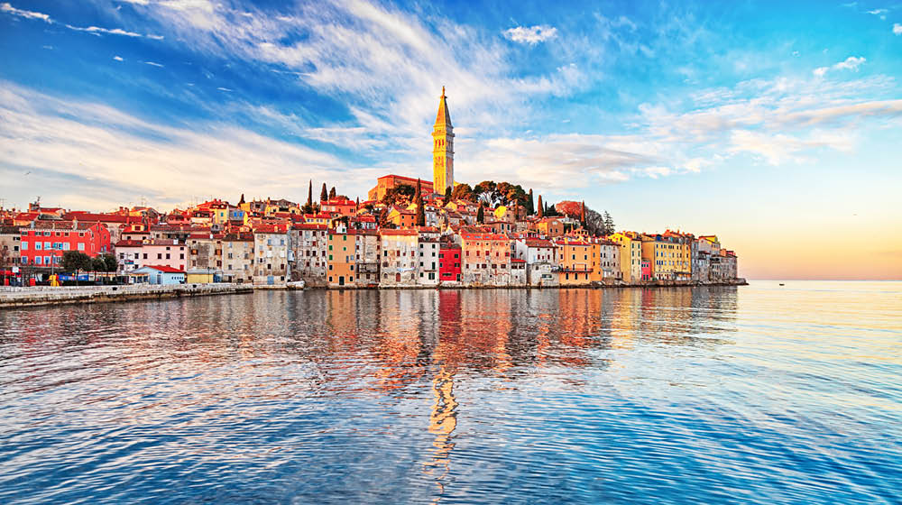 View of old town Rovinj with reflections on calm sea.