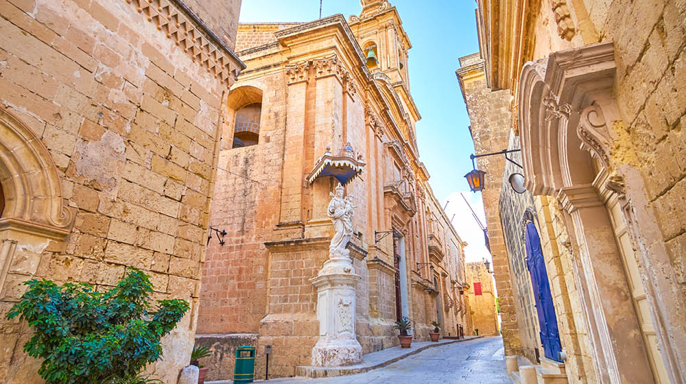 The crossroad in Mdina fortress with Annunciation Church with sculpture to Virgin Mary in the corner, Malta