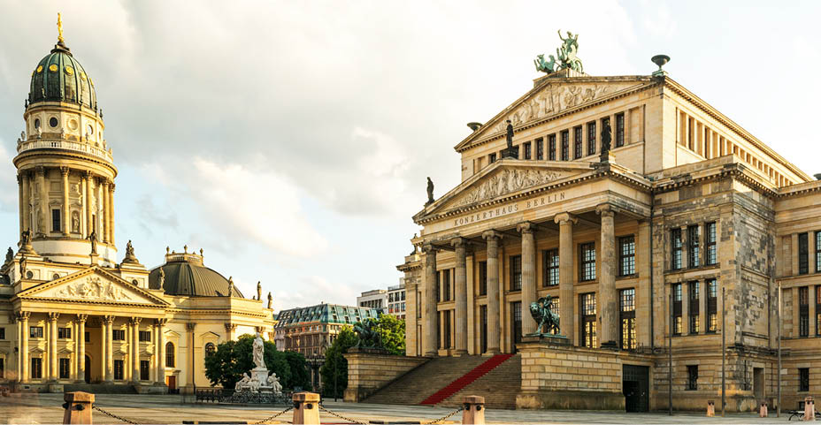 Panoramic Gendarmenmarkt square with German Cathedral in golden evening light at sunset with clouds, Berlin Mitte district