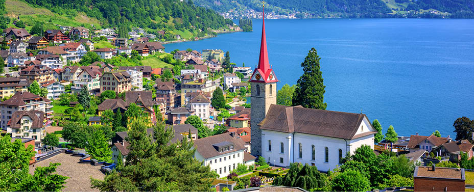Little swiss town with gothic church on Lake Lucerne and Alps mountain, Switzerland
