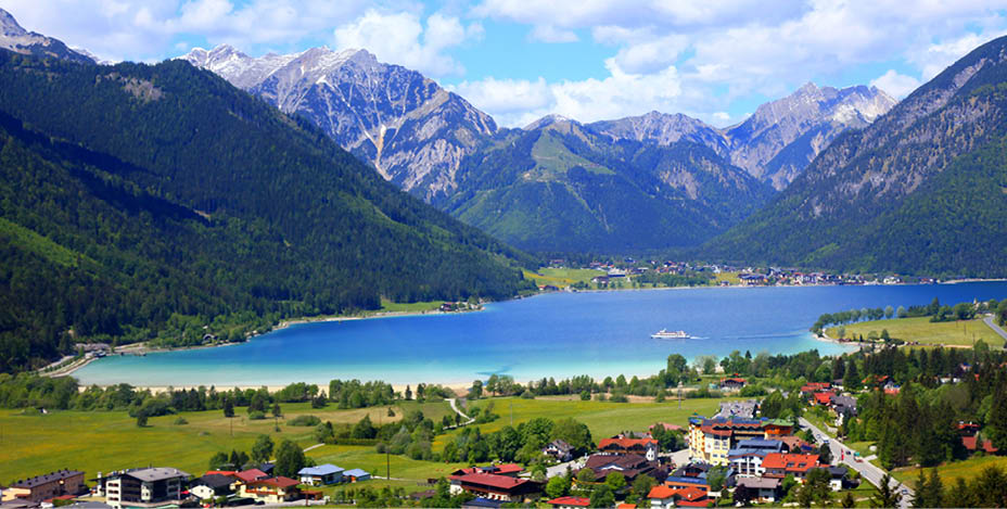 Above Idyllic Achensee turquoise lake reflection, alpine landscape in Austrian Tirol - Karwendel mountain range border with Bavarian alps in Germany - Majestic alpine landscape in gold colored autumn, dramatic Tyrol Snowcapped mountains panorama, Austria