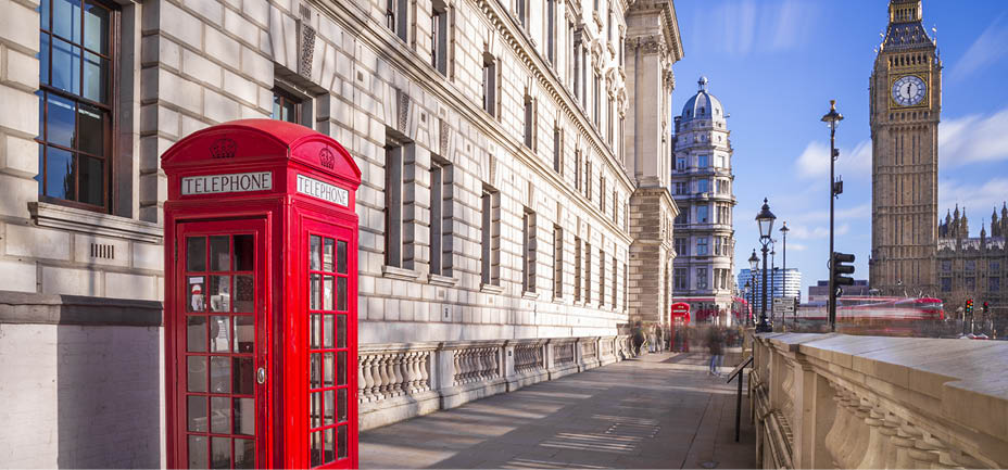 Traditional red british telephone box with Big Ben and Double Decker bus at the background on a sunny afternoon with blue sky and clouds - London, UK
