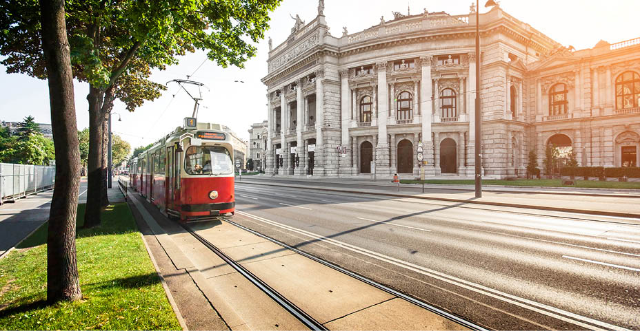 Beautiful view of famous Wiener Ringstrasse with historic Burgtheater (Imperial Court Theatre) and traditional red electric tram at sunset in Vienna, Austria