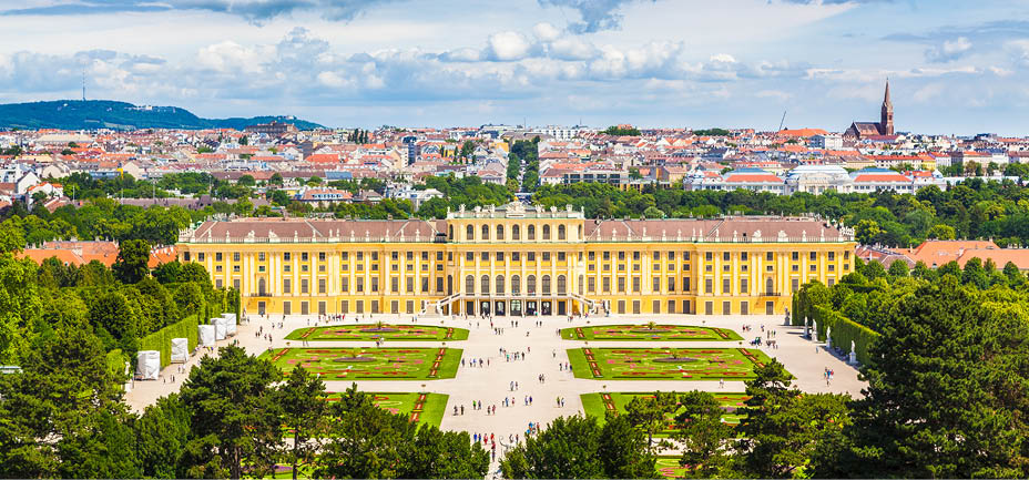 Classic view of famous Schonbrunn Palace with scenic Great Parterre garden on a beautiful sunny day with blue sky and clouds in summer, Vienna, Austria