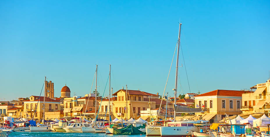 Yachts and boats in the harbour and waterfront in Aegina town at sunset, Aegina Island, Greece