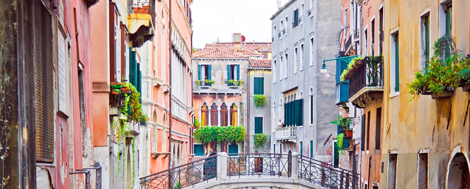 A canal and old white bridge in Venice, Italy