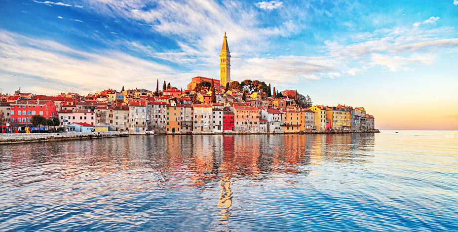 View of old town Rovinj with reflections on calm sea.