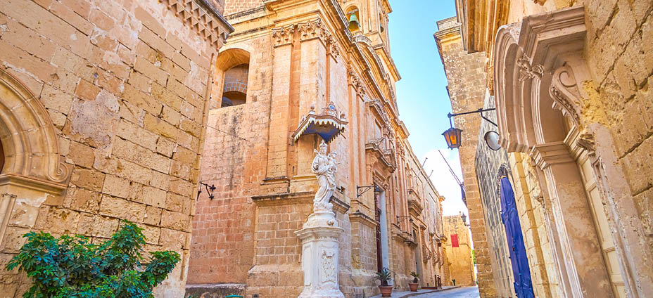 The crossroad in Mdina fortress with Annunciation Church with sculpture to Virgin Mary in the corner, Malta