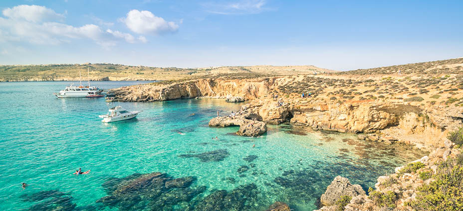 The world famous Blue Lagoon in Comino island - Mediterranean nature wonder in the beautiful Malta - Unrecognizable international tourist people and snorkeling divers - Exclusive travel destinations